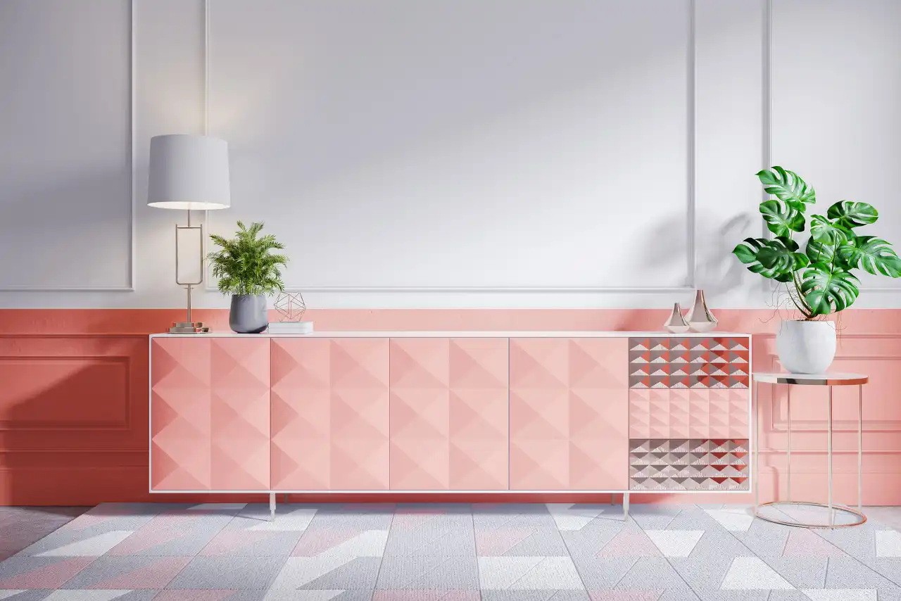 Modern living room featuring a pink and coral geometric sideboard against a wainscoting wall, with large indoor plants and a floor lamp.