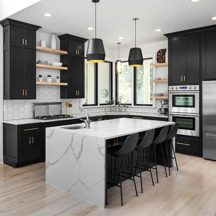 Modern kitchen featuring sleek black shaker cabinets with gold hardware, a white quartz island with dramatic gray veining, open wooden shelves, and a white hexagon tile backsplash.
